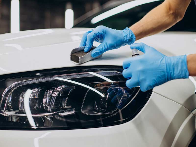 Cropped image of Hands of worker doing paint protection of car.